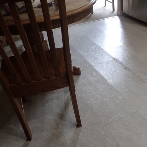cupped vinyl tiles from water leak in adjacent room
